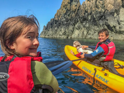2 young people with a small dog enjoying Kayaking at Abercastle Campsite, a dog friendly campsite